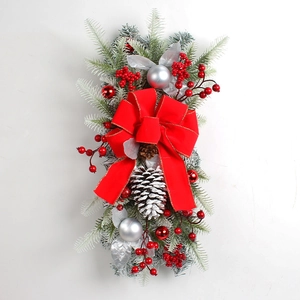 Detail of Christmas teardrop swag with frosted leaves, red berries, and a large red bow