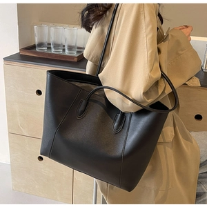 Classic black tote bag shown with a khaki coat for an elegant professional commuter look