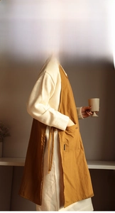 Detail of tan cotton linen apron with side ties and a large front pocket for kitchen work