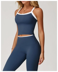 Détail de l'ensemble de yoga bleu marine avec bordures blanches sur le crop top et le legging