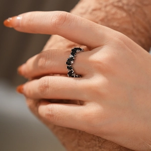 Macro shot of an irregular wavy ring featuring baguette-cut black zircons and micro-diamonds