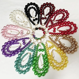 Flat lay of double-layer pearl necklace and earring sets in ten vibrant colors