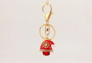 Close-up of a cute Christmas snowman keychain with red hat and sparkling crystal rhinestones