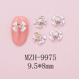 Macro shot of silver bow nail charms with amber heart gems, size 9.5x8mm for DIY manicure