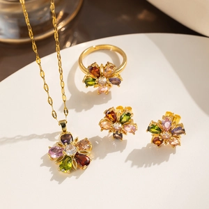 Floral jewelry set with colorful stones on a white plate including necklace and ring