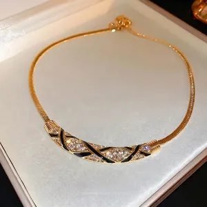 Vintage gold necklace with black enamel and diamonds on elegant jewelry box background