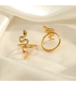 Macro shot of gold snake rings with colorful crystal inlay on luxury silk fabric