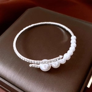 Macro view of silver wrap bracelet with white pearls and sparkling diamond accents