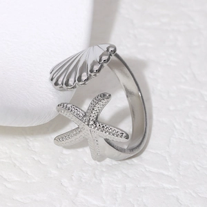 Macro detail of adjustable starfish and seashell ring with textured metal finish