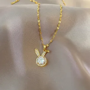 Exquisite golden rabbit pendant necklace with sparkling cubic zirconia on purple silk