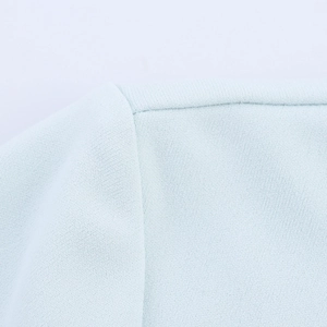 Dettaglio di un abito azzurro con cuciture in mesh e fine trama del tessuto chiffon