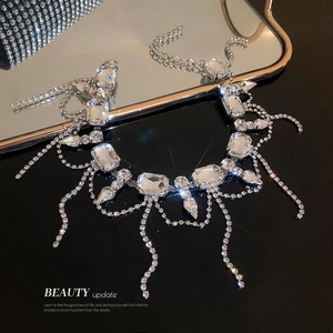 Elegant silver tassel necklace with oversized rectangular rhinestones on a mirror surface
