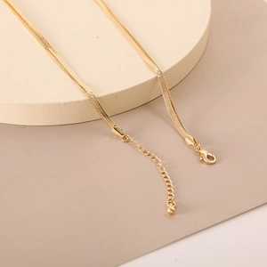 Detailed view of golden double-layer snake chain necklace with lobster clasp and extension