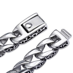 Detailed close-up of a silver men's Cuban link bracelet with black engraved vine patterns