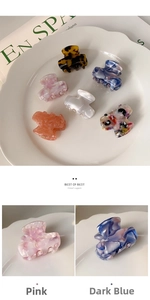 Set of mini acetate hair claws in various marble colors and floral patterns in a ceramic dish