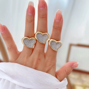 Elegant gold plated heart ring with zircon stones shown on hand in a three-piece set
