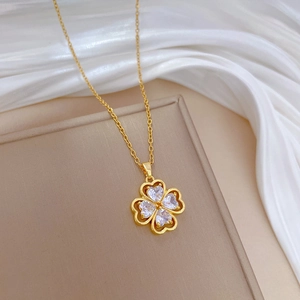 Detailed close-up of lucky clover pendant with crystals on elegant gold titanium chain