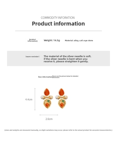 Detailed view of vintage teardrop earrings featuring orange cat eye stone and pearls