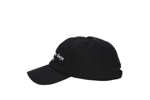Close-up of retro 'some days' white embroidery on a black cotton twill baseball cap