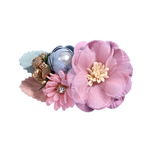 Elegant floral hair clip with rhinestones, pearls and pastel petals in a 45-degree view