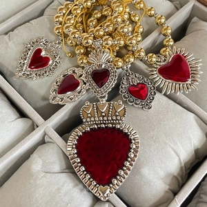 Vintage red heart enamel charms with gold bead necklace set on grey jewelry pillow