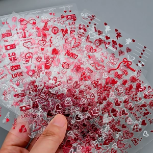 Detail of red metallic heart and love nail stickers for Valentine nail decoration