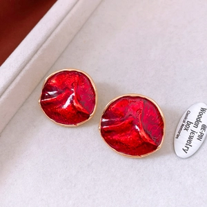 Close-up of red enamel round wrinkled earrings with gold trim in a vintage style box