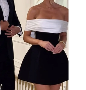 Detail of off-shoulder black and white bodycon dress featuring a bow-knot neckline