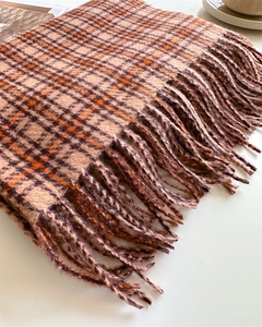Close-up of warm brown and orange plaid scarf fringe and thick knitted texture