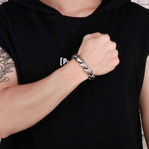 Close-up of vintage silver steel dragon scale chain bracelet worn on a man's wrist