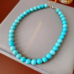 Detail of turquoise beaded necklace showing natural stone texture and silver lobster clasp