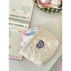 Borsa trapuntata color crema con ricamo a cuore leopardato viola sulla scrivania