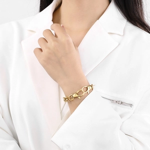 Close-up of golden stainless steel chain bracelet with lobster clasp design on model