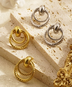 Detail of vintage geometric textured triple hoop earrings in gold and silver finish