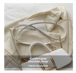 Detail of white litchi pattern bag with gold square buckle and slim leather strap