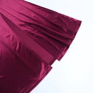 Détail de la couture de la fente latérale et du tissu satiné d'une robe de soirée bordeaux