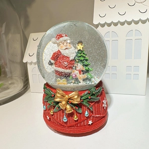 Christmas snow globe music box with red base, green tree and festive Santa Claus scene