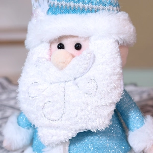 Dettaglio di Babbo Natale in peluche blu e bianco con paillettes e texture a maglia