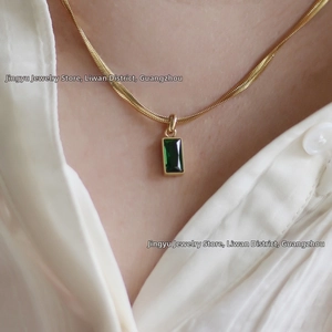 Détail du collier chaîne serpent en or 18K avec pendentif vert émeraude carré