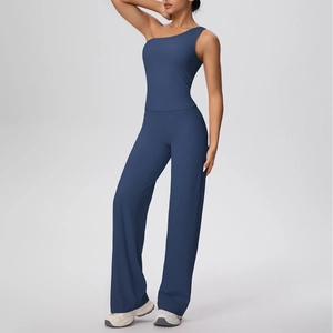Détail du haut de yoga asymétrique bleu marine et pantalon large en tissu mat et doux