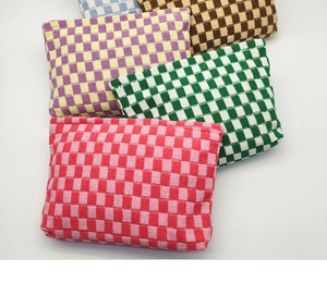 Detail showing five knitted gingham pouches in various colors with thick woven texture