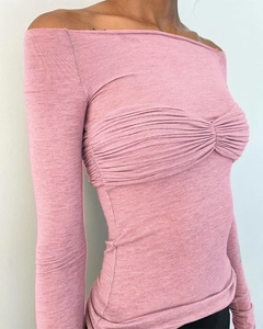 Gros plan du haut en tricot rose à épaules dénudées avec buste froncé et coupe moulante