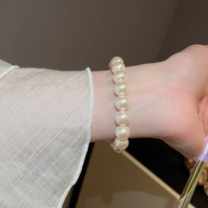 Gros plan d'un bracelet de perles plaqué or 18 carats avec zircons porté par un mannequin