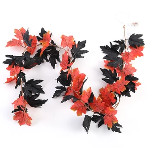 Detail of fall maple leaf garland with red black leaves and LED battery box