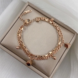 Detail of rose gold double-layer bracelet with cube charms on a jewelry display box