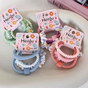 Sets de 4 chouchous aux couleurs macaron avec élastiques spirales présentés sur plateau