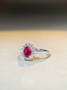 Macro detail of oval red zircon ring with double halo pavé setting in S925 silver