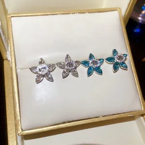 Star-shaped silver earrings with sparkling zircon crystals in white and blue shades
