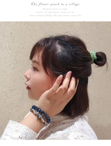 Détail de chouchous et bracelets perlés portés au poignet et sur un chignon