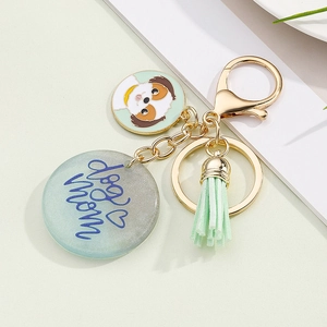 Detail of colorful resin keychain with dog mom lettering and green tassel on metal ring